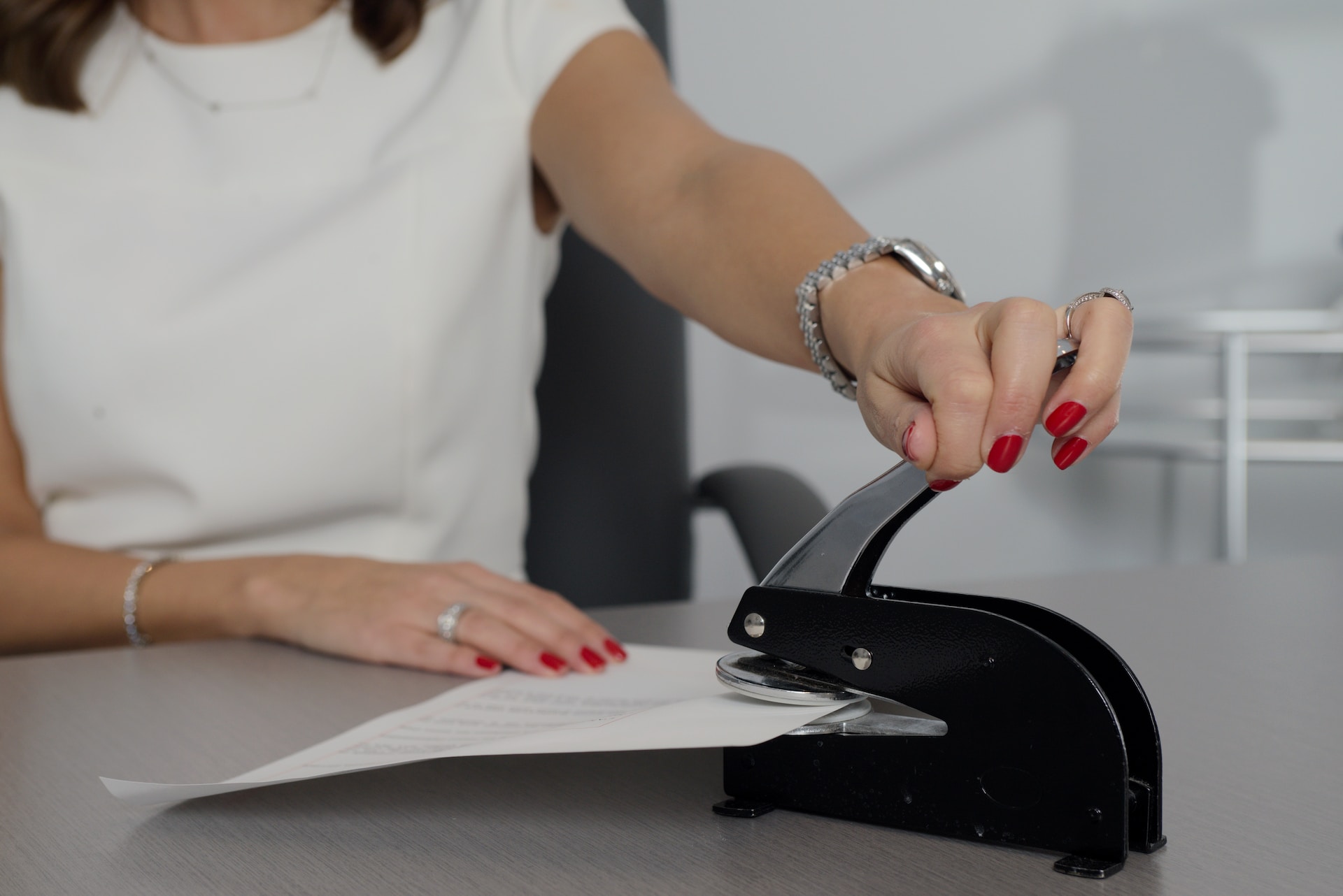 A woman stamping an important document at a desk.